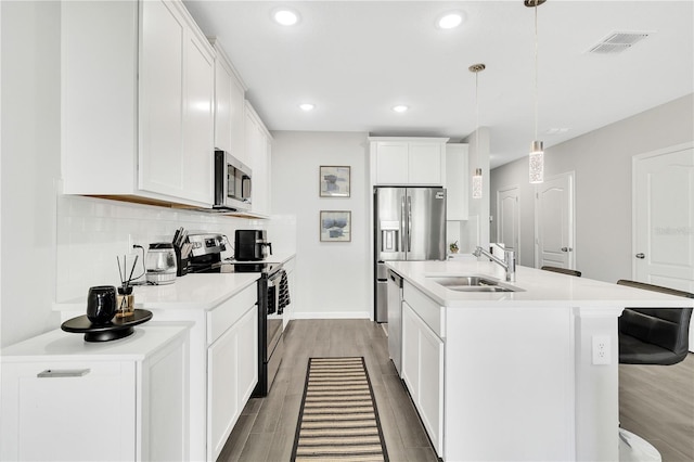 kitchen with tasteful backsplash, visible vents, appliances with stainless steel finishes, wood finished floors, and light countertops