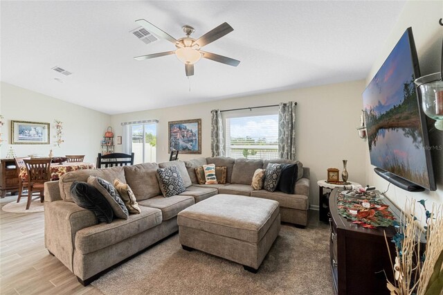 living area with light wood-type flooring, visible vents, and a ceiling fan