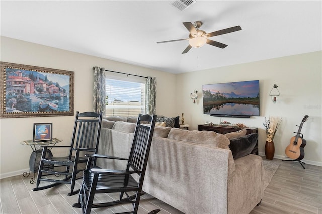 living area with ceiling fan, wood finish floors, visible vents, and baseboards