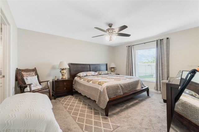 bedroom featuring light carpet and a ceiling fan