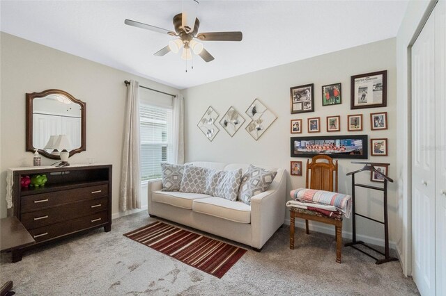 sitting room featuring carpet floors, baseboards, and a ceiling fan