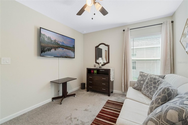 living area with light carpet, ceiling fan, and baseboards