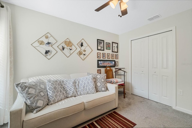 carpeted living room featuring ceiling fan, visible vents, and baseboards