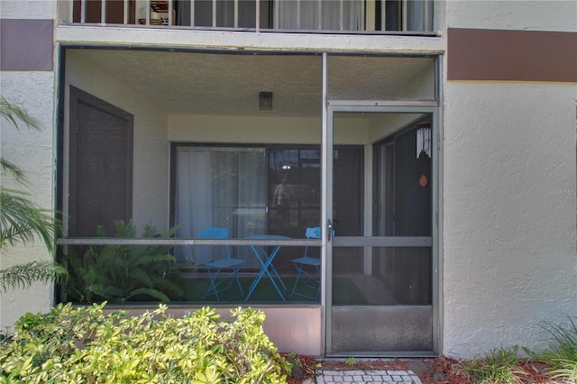 doorway to property featuring stucco siding