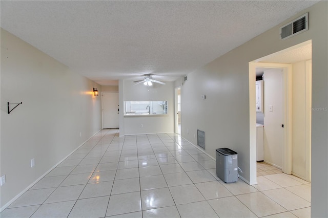 empty room with light tile patterned floors, ceiling fan, visible vents, and a textured ceiling