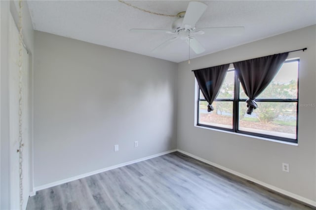 unfurnished room with ceiling fan, baseboards, and wood finished floors