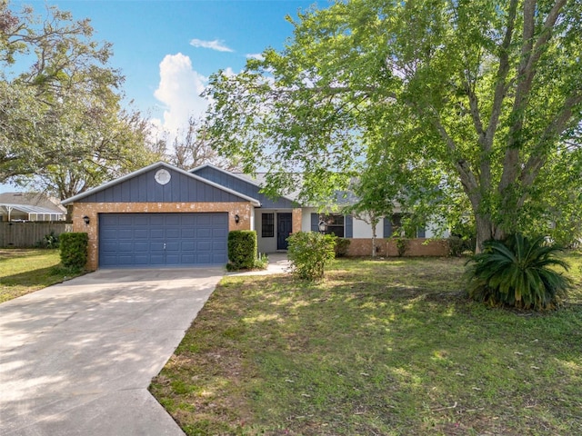 view of front of property featuring a garage, concrete driveway, brick siding, and a front yard