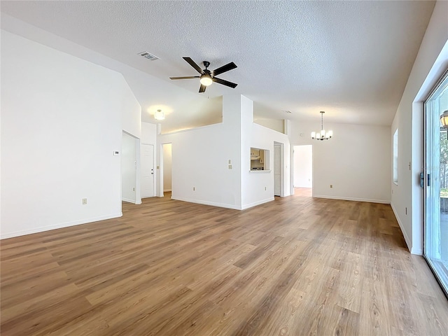 unfurnished living room featuring visible vents, lofted ceiling, wood finished floors, a textured ceiling, and ceiling fan with notable chandelier