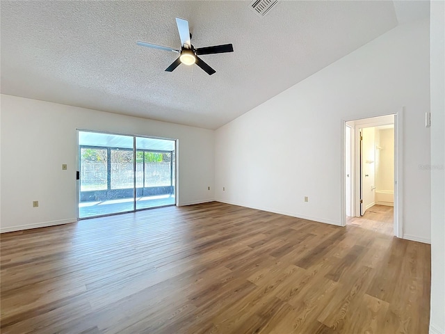 spare room with visible vents, ceiling fan, vaulted ceiling, a textured ceiling, and wood finished floors