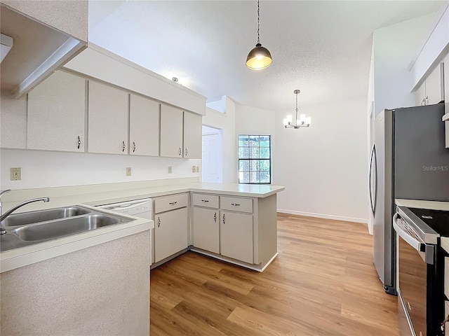 kitchen featuring light wood-style flooring, a peninsula, stove, a sink, and pendant lighting