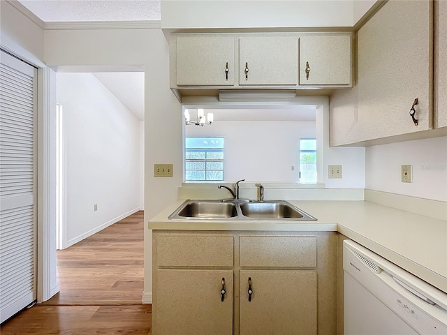 kitchen featuring a sink, baseboards, light wood-style floors, light countertops, and dishwasher