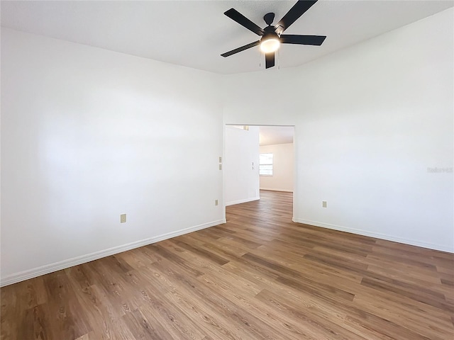 unfurnished room featuring wood finished floors, a ceiling fan, and baseboards