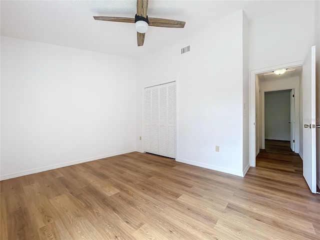 unfurnished bedroom with a closet, light wood-type flooring, visible vents, and baseboards