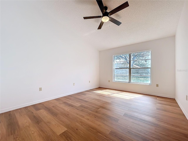 unfurnished room with a textured ceiling, wood finished floors, a ceiling fan, and baseboards