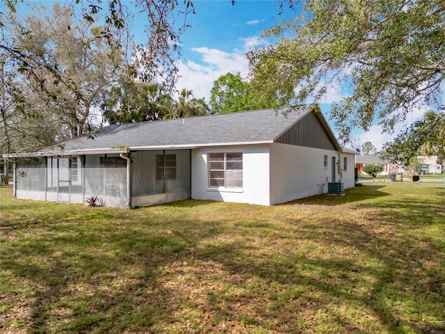 rear view of property featuring a yard and central air condition unit