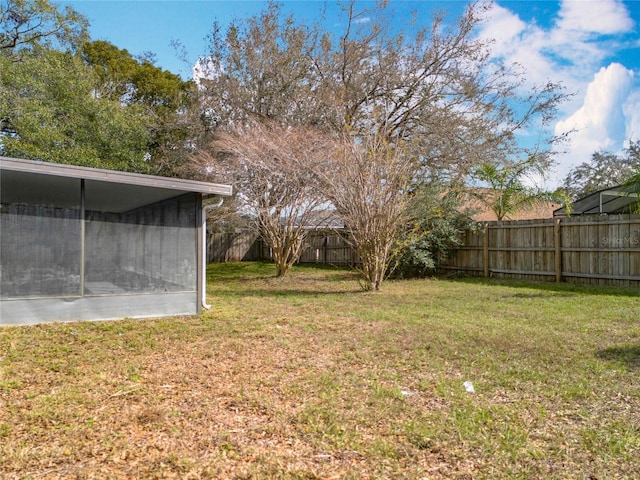 view of yard featuring a sunroom and a fenced backyard