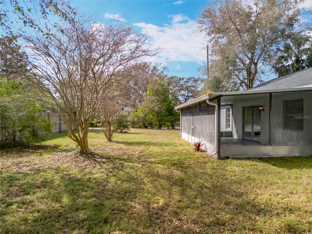 view of yard featuring a sunroom and fence