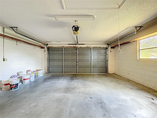 garage with concrete block wall and a garage door opener