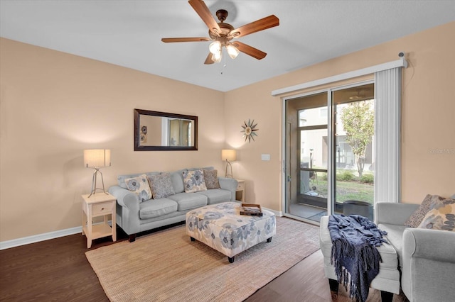 living area featuring wood finished floors, a ceiling fan, and baseboards