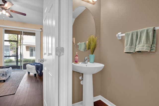 bathroom with ceiling fan, baseboards, and wood finished floors