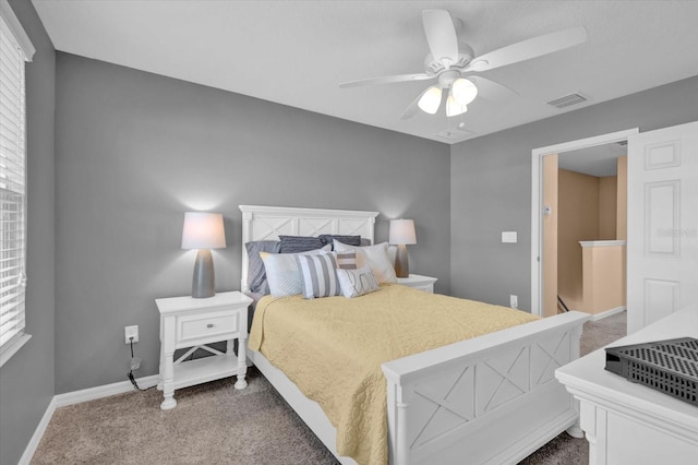 carpeted bedroom featuring baseboards, visible vents, and a ceiling fan