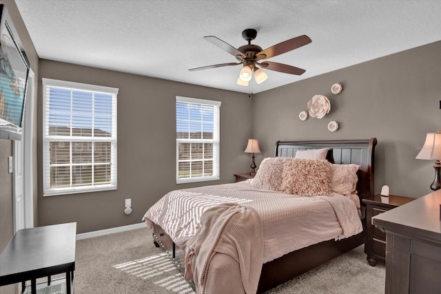 bedroom featuring light carpet, a textured ceiling, a ceiling fan, and baseboards