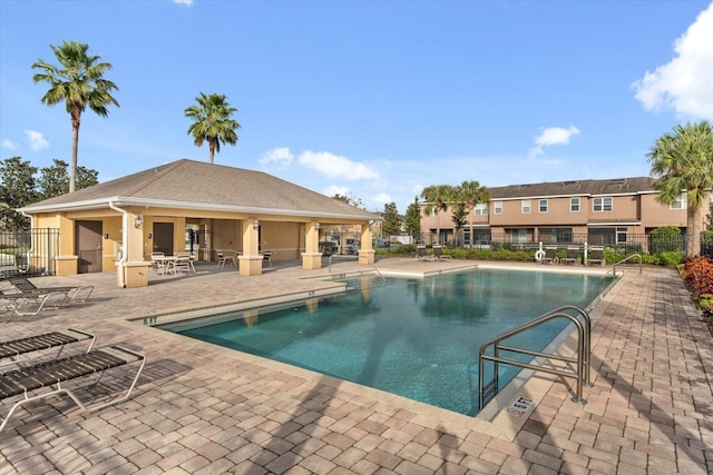 community pool with a patio and fence