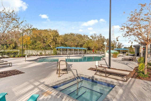 pool with a community hot tub, a patio, and fence