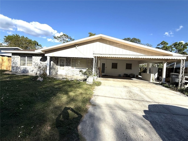 view of front facade with a carport, a front lawn, and driveway