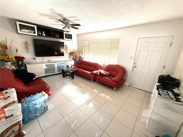 living area with a textured ceiling, a ceiling fan, and tile patterned floors