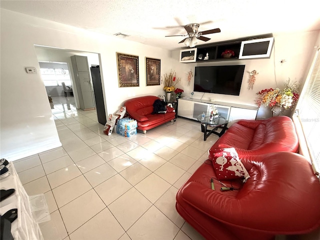 living area featuring visible vents, ceiling fan, a textured ceiling, and light tile patterned flooring