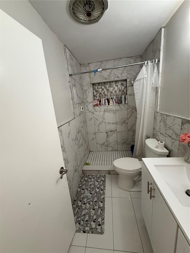 full bathroom featuring a stall shower, tile walls, toilet, and vanity