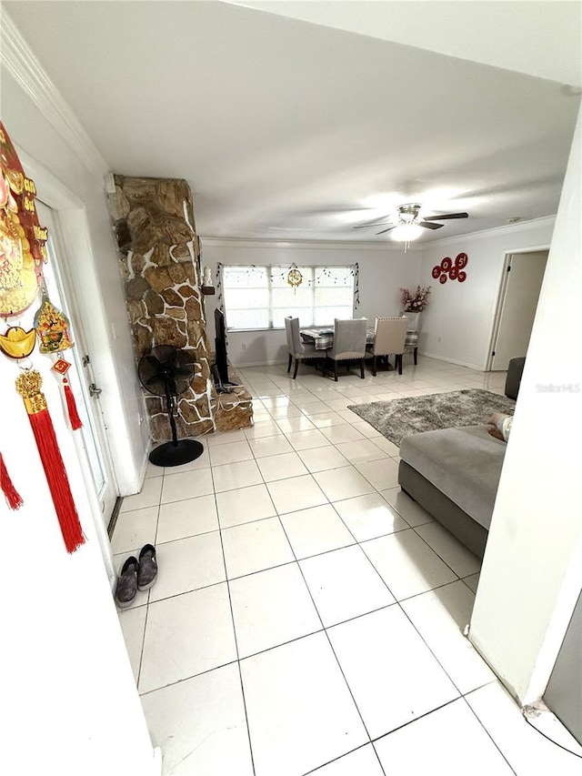 living room with ornamental molding, light tile patterned flooring, ceiling fan, and a fireplace