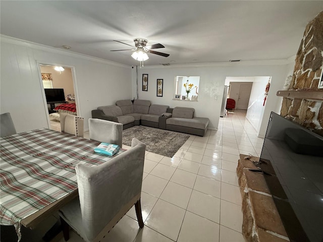 living room with light tile patterned floors, ornamental molding, visible vents, and a ceiling fan