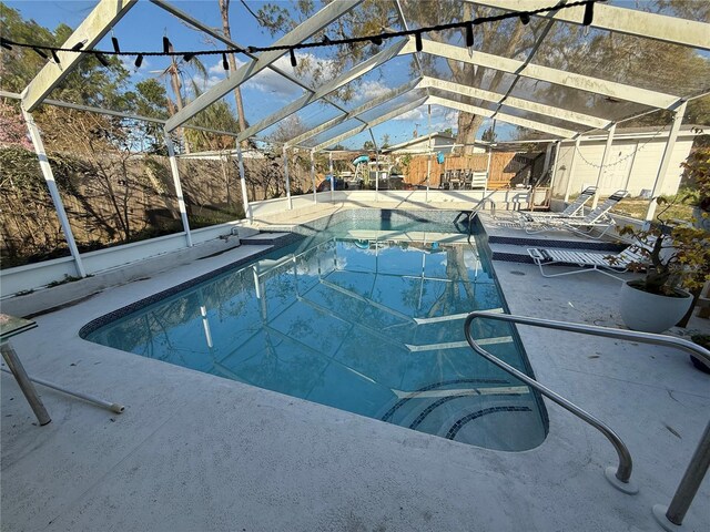 pool featuring a patio area and glass enclosure