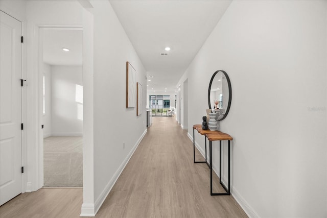 corridor with light wood-style floors, recessed lighting, visible vents, and baseboards