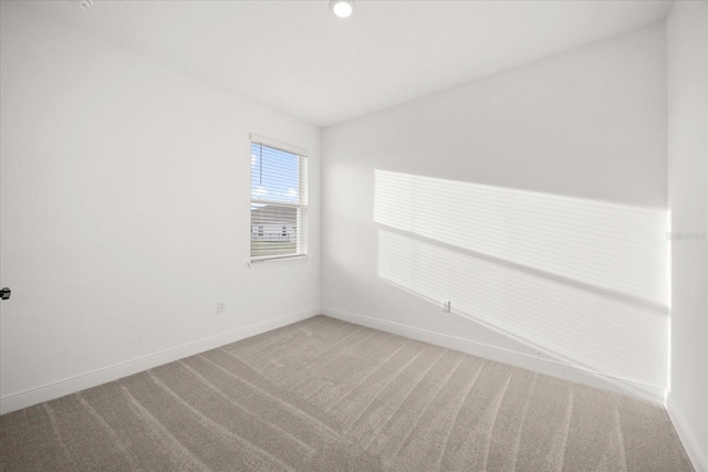 carpeted spare room with baseboards