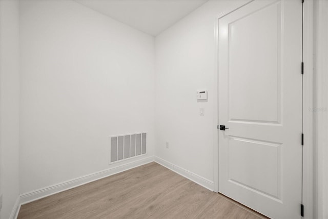 spare room featuring light wood-type flooring, baseboards, and visible vents