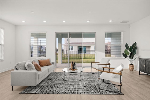 living room with recessed lighting, wood finished floors, visible vents, and baseboards