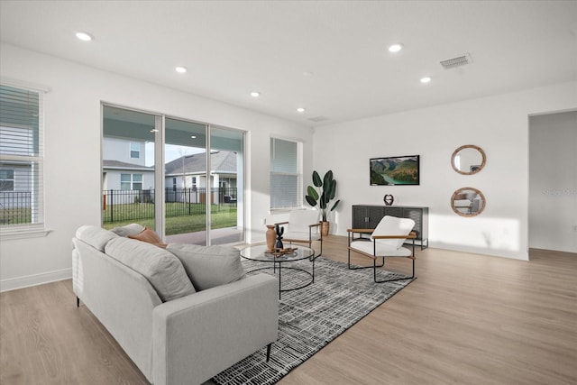 living room featuring recessed lighting, visible vents, a wealth of natural light, and wood finished floors