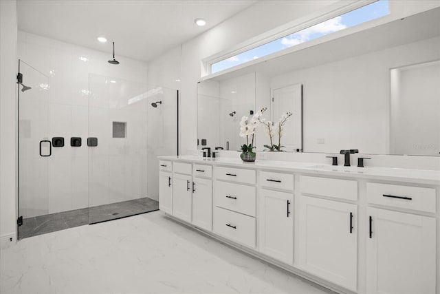 full bath with a stall shower, marble finish floor, a sink, and double vanity