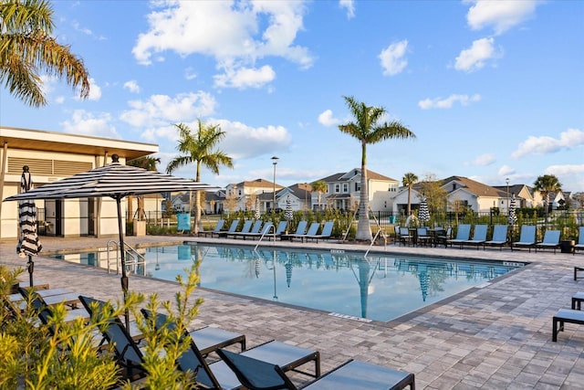 view of pool featuring a residential view, fence, and a patio