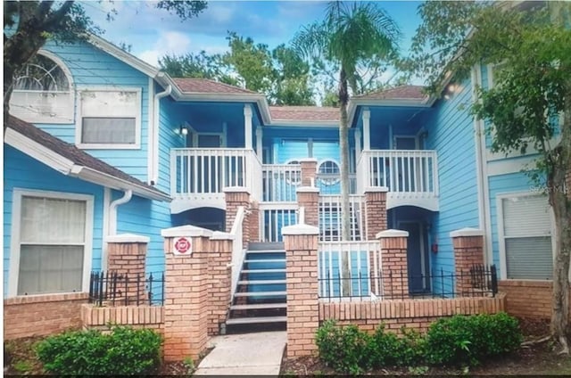 view of front facade with brick siding and stairway