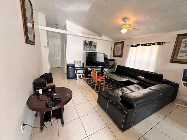 living area with a ceiling fan, vaulted ceiling, a textured ceiling, and light tile patterned floors