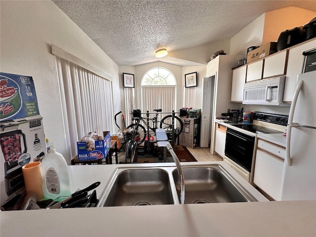 4954 Luna Negra Dr, Orlando, FL 32811 - kitchen featuring white appliances, light countertops, vaulted ceiling, and a textured ceiling