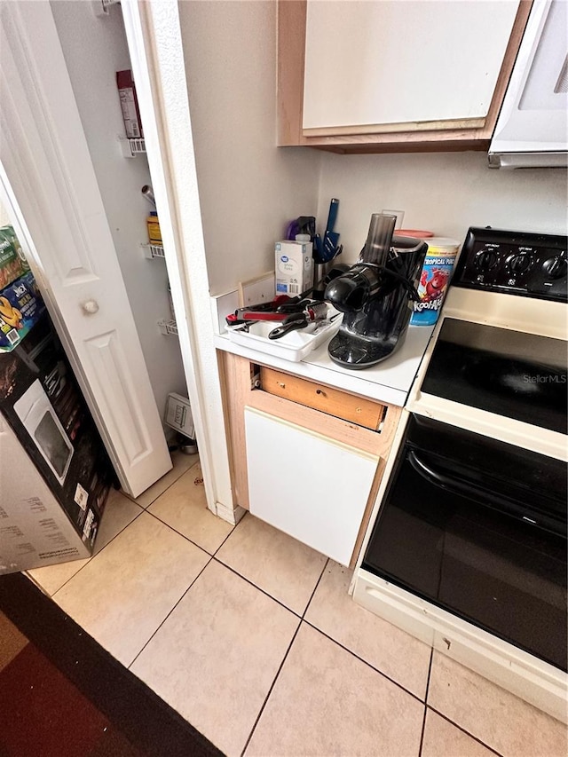 4954 Luna Negra Dr, Orlando, FL 32811 - kitchen with light countertops, light tile patterned flooring, white microwave, and stove