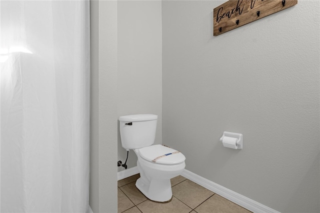 bathroom featuring baseboards, toilet, and tile patterned floors