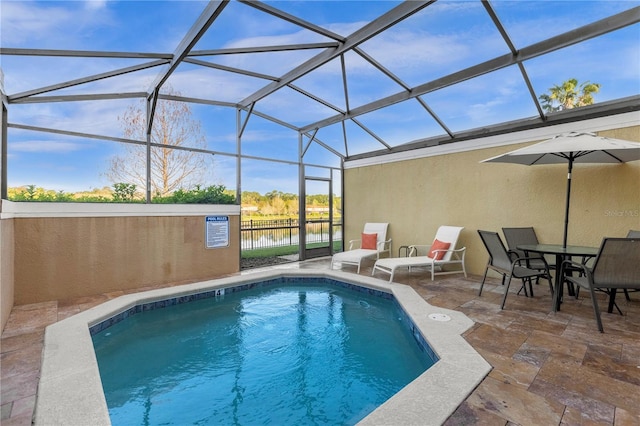 pool featuring a patio, a water view, fence, and a lanai