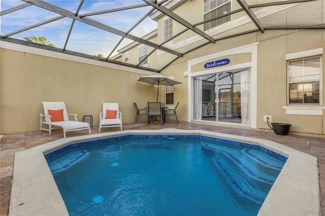 view of swimming pool with glass enclosure and a patio