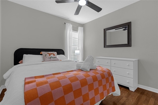 bedroom featuring dark wood-type flooring, ceiling fan, and baseboards